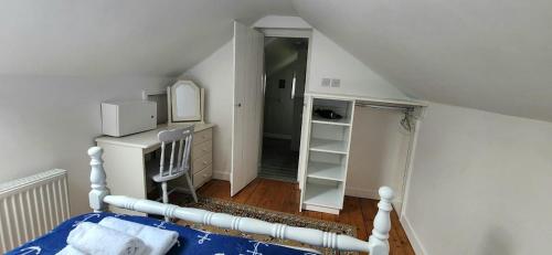 1 dormitorio con cama blanca y espejo en 1844 Seascape Cottage Is located on the Wild Atlantic Way, en Fanore