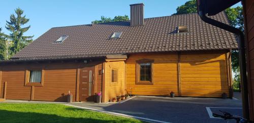 uma grande casa de madeira com uma grande garagem em U MARTUŚKI DOMKI POKOJE POD LASEM em Stegna
