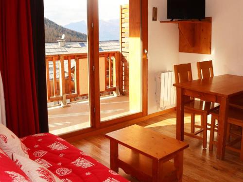 d'un salon avec une table et une vue sur un balcon. dans l'établissement Appartement 4 pers, piscine, jacuzzi & skis aux pieds - Les Orres - FR-1-322-425, aux Orres
