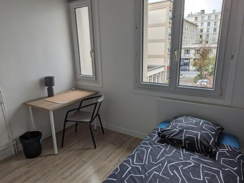 a bedroom with a bed and a desk and a window at Chambre cœur du centre-ville in Le Havre