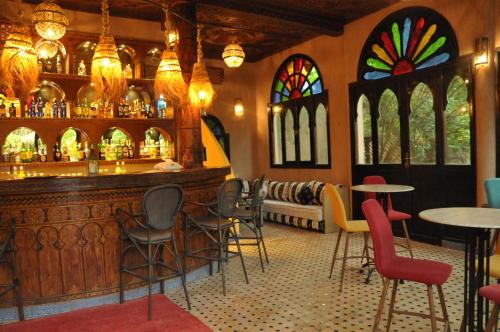a bar in a restaurant with chairs and tables at OZ Palace Ouarzazate & SPA in Ouarzazate
