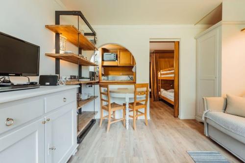 cocina con escritorio y mesa con silla en Alpes Bellevue furnished flat, en Les Houches