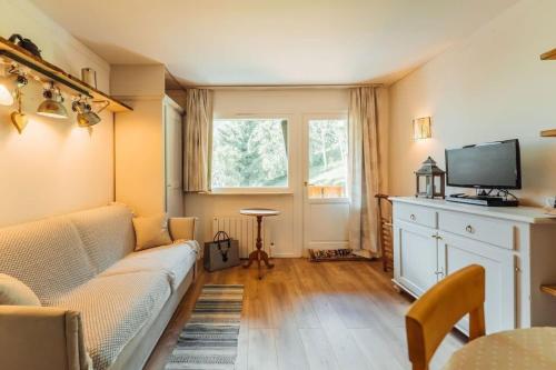 - un salon avec un canapé et une télévision dans l'établissement Alpes Bellevue furnished flat, aux Houches