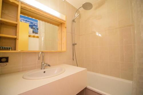 een badkamer met een wastafel, een spiegel en een bad bij CHEVAL NOIR G - Appartement CHEVAL NOIR 23 pour 4 Personnes 22 in Valmorel
