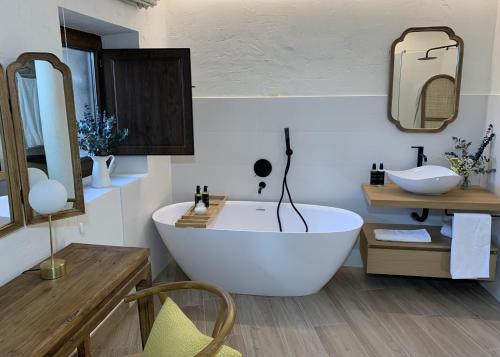 a bathroom with a large white tub and a sink at HOTEL RURAL SANTUI in Horcajuelo de la Sierra