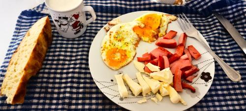 a plate of breakfast food with an egg and fruit at Etno Selo Ja. in Nikšić
