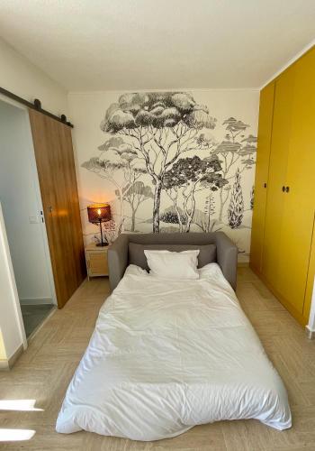 Ce lit se trouve dans un dortoir orné d'une fresque murale représentant les arbres. dans l'établissement Studio avec vue sur Marina et Mer - 2 adultes et 1 enfant maximum, à Mandelieu-la-Napoule