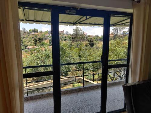 a room with a window with a view at Haven Guest House in Kodaikānāl
