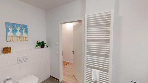 Łazienka z białymi ścianami i białą szafą w obiekcie Südkap E-03 w mieście Pelzerhaken