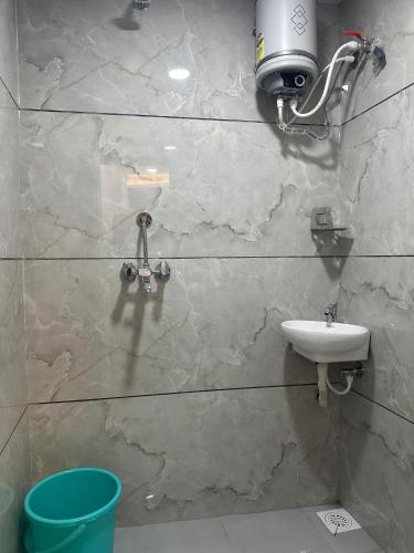 a bathroom with a toilet and a sink on a wall at Hotel Hakimi in Ujjain