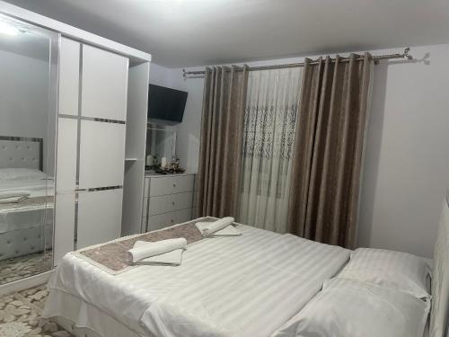 een witte slaapkamer met een bed en een dressoir bij Casa DAIANA in Moisei