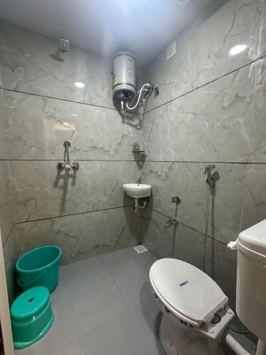 a bathroom with a toilet and a sink at Hotel Hakimi in Ujjain
