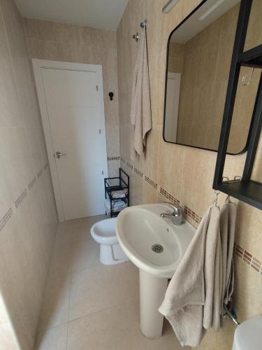 a bathroom with a sink and a mirror and a toilet at Casa Al Castello in Cómpeta
