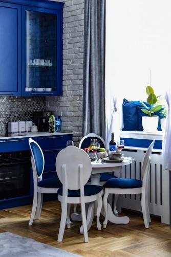 a kitchen with blue cabinets and a table and chairs at Supreme Tatarska in Przemyśl