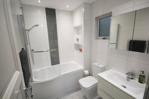 La salle de bains est pourvue d'une baignoire, de toilettes et d'un lavabo. dans l'établissement Private Estate Lake Lodge-Cabin Near River Thames, à Buckinghamshire