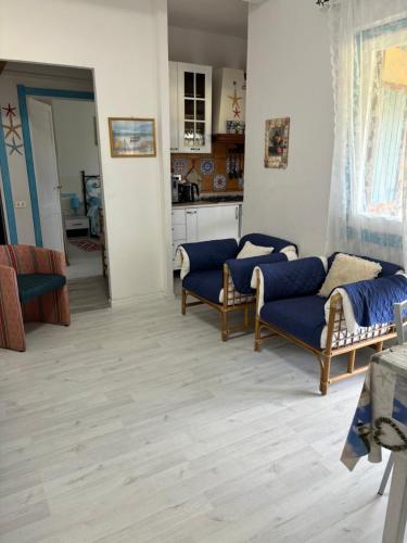 a living room with two blue couches and a kitchen at appartamento al mare vicino Olbia in Murta Maria