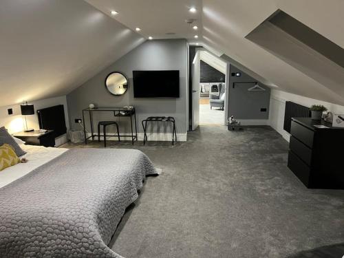 een slaapkamer met een bed en een flatscreen-tv bij Waters Edge, Eaton in Congleton
