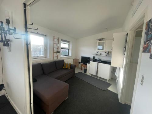 Airport Room في كوبنهاغن: غرفة معيشة مع أريكة ومطبخ