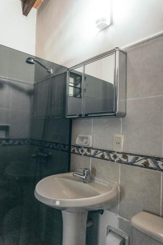 a bathroom with a sink and a mirror on the wall at Quinta La Paloma in Itauguá