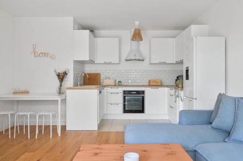 un salon avec un canapé bleu et une cuisine dans l'établissement Le Lumina - 6 pers - Proche Orly - Jardin, à Rungis