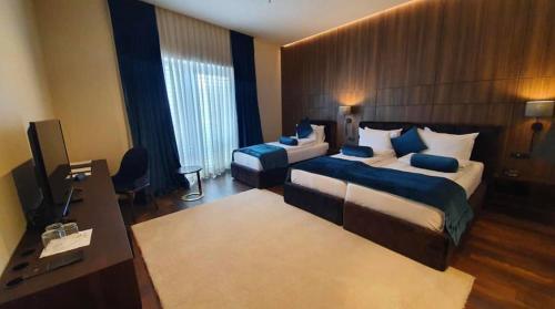 a hotel room with two beds and a television at Premium Park Hotel in Prizren