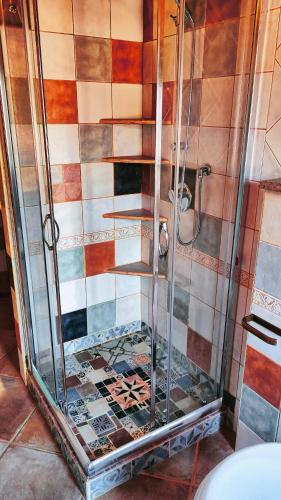 a shower in a bathroom with a tile wall at Casa Gaudi - House & Rooms in Teulada