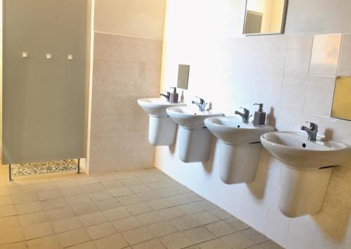La salle de bains est pourvue de 3 lavabos et de 2 miroirs. dans l'établissement Budova U dvojice, à Nové Město na Moravě