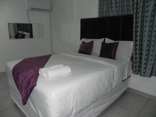 a bedroom with a large bed with towels on it at De Bliss Lodge in Johannesburg