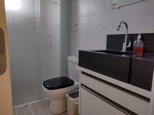 La salle de bains est pourvue d'un lavabo noir et de toilettes. dans l'établissement Pertinho do Beto Carrero Jw, à Navegantes