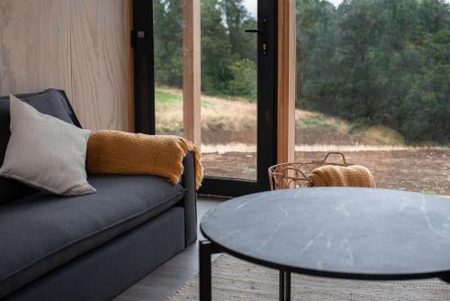 a living room with a couch and a table and a window at Cabaña en Rio Maullin Nek #1 in Las Quemas del Salto