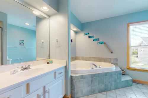 a bathroom with two sinks and a bath tub at Argonauta #27-2 in Avon