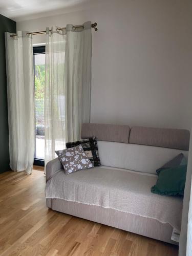 a couch in a living room with a window at Apartman s terasou, v novostavbe in Prague