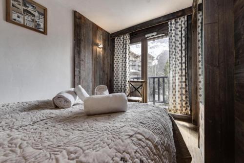 een slaapkamer met een bed met twee handdoeken erop bij Residence Venus - 3 Pièces pour 4 Personnes 894 in Val dʼIsère
