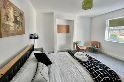 a bedroom with a bed and a chair and a window at Golden Triangle Townhouse in Norwich