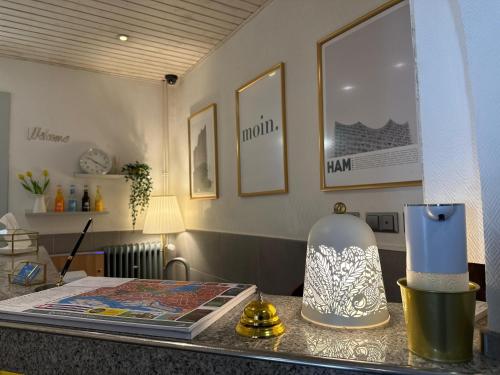 a table with a lamp and a book on it at Hotel Kieler Hof am Hauptbahnhof - Hamburg Central Station in Hamburg