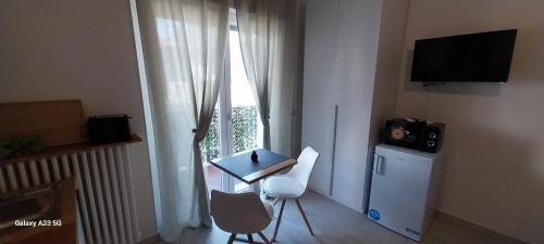 een kamer met een tafel, een televisie en een raam bij Little Sweet Home - Fiera Milano in Pero