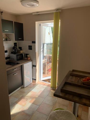 a kitchen with a door open to a kitchen with a table at Sous Les Chênes in Saint-Martin-de-Brômes