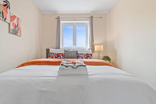 1 cama blanca grande en una habitación con ventana en Cosy 3 Bedroom Spacious house., en Romford
