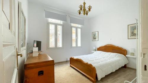 een slaapkamer met een bed, een bureau en ramen bij Bright & Spacious Apartment near city center. in Thessaloniki
