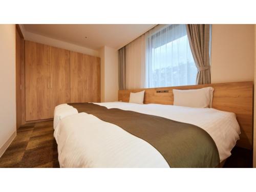 een hotelkamer met 2 bedden en een raam bij Rembrandt Hotel Atsugi - Vacation STAY 41678v in Atsugi