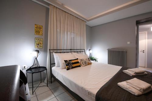 Schlafzimmer mit einem Bett mit weißer Bettwäsche und einem Fenster in der Unterkunft Our Happy Place Maisonette in Kavala