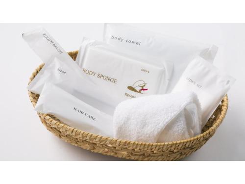 una cesta con toallas blancas y otros artículos en Rembrandt Hotel Atsugi - Vacation STAY 41675v en Atsugi