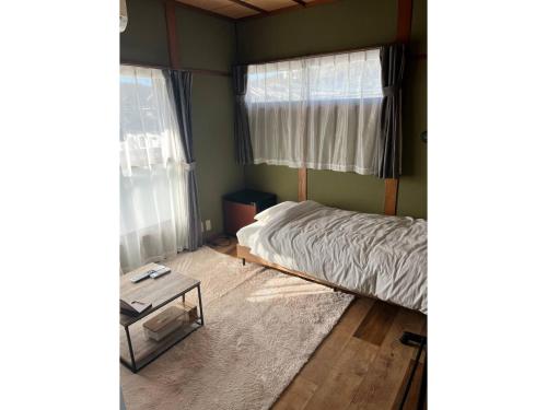 宮崎市にあるGUEST HOUSE aoshima tei - Vacation STAY 42002vの小さなベッドルーム(ベッド1台、テーブル付)