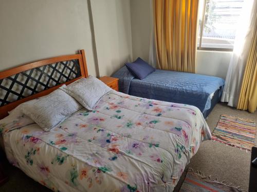 a bedroom with a bed and a bed and a window at Delpino Propiedades Veracruz in Viña del Mar