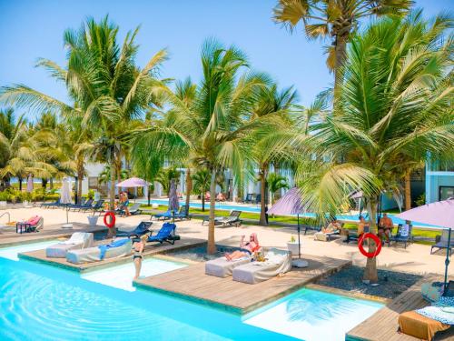 a resort with palm trees and a swimming pool at Tamala Beach Resort in Kotu