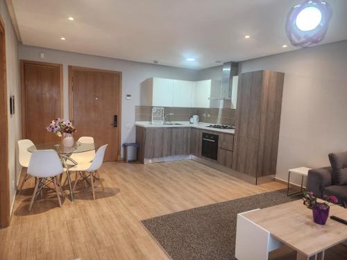 a kitchen and a living room with a table and chairs at Casablanca Marina by Saloua in Casablanca