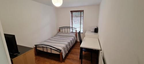 Un dormitorio pequeño con una cama y un escritorio. en Luton LU2 Ensuite room, en Luton