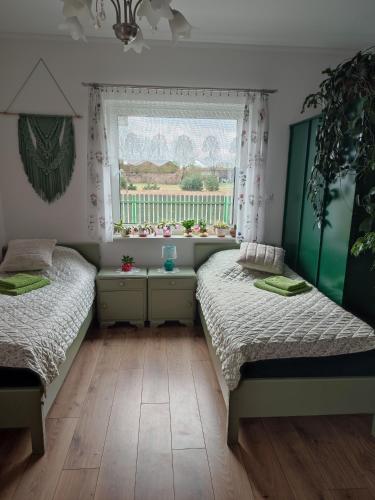 two beds in a room with a window at Zielona Przystań in Boruja