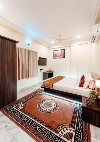 Habitación de hotel con cama y TV en Paradise Inn en Indore