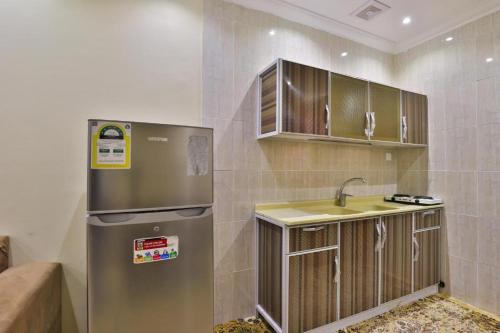 a kitchen with a refrigerator and a sink at نجمة سماء ينبع للشقق المفروشة in Madīnat Yanbu‘ aş Şinā‘īyah
